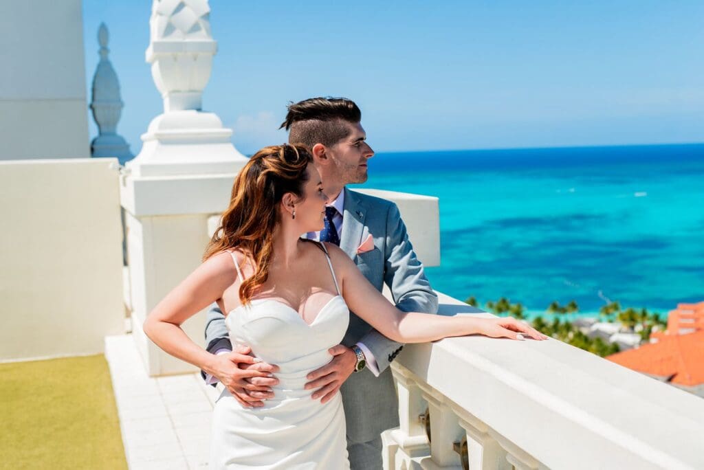 Bride and groom at resort in the Bahamas looking over turquoise waters